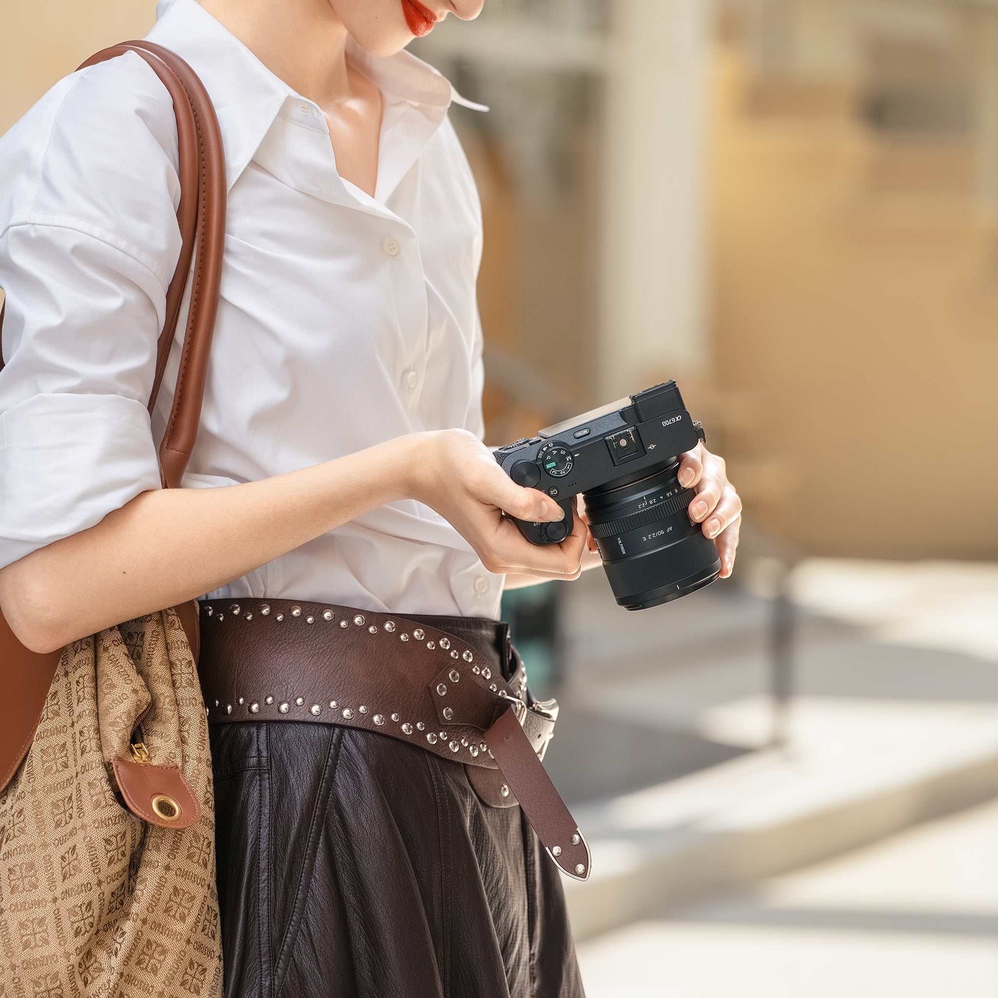 Kompaktný objektív Viltrox AF 90 mm F2,2 E v ruke